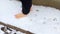 Woman walking barefoot in snow. Close-up of mans bare feet. Hardening of body by walking in snow