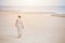 Woman walking on the beach alone lonely with space for text