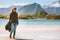 Woman walking on beach alone in Norway summer vacations trip outdoor