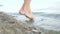 Woman walking on beach barefoot. Girl walking in shallow water at sunset and enjoying nature.