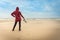 Woman walking on beach with camera