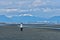 Woman walking on beach with downtown Vancouver and mountains view.