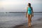 Woman walking on the beach and enjoying the sunrise on the caribbean sea in an environment of wellness and relaxation in Playa