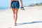 Woman walking on the beach next to ocean