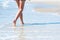 Woman walking on the beach next to ocean