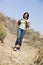 Woman walking on beach path smiling