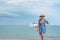 Woman walking on beach with yacht in background