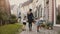 Woman walking with boy and girl, holding hands. Mother, two little kids. Half-timbered houses Hattingen Germany. 4K.