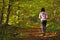 Woman walking cross country trail in autumn forest