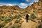 Woman walking is a desert with eroded rocks