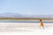 Woman walking in desert with umbrella