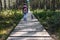 Woman walking dog on wooden pathway in the woods