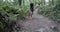 Woman walking with dogs on forest path