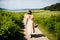 Woman walking down a path with a bouquet of flowers.