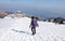 Woman walking down the snowy slope of Monte Grappa in Northern Italy i