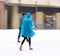 Woman walking down the street in winter snowy day in motion blur