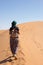 Woman walking in the dunes in the Moroccan Sahara desert