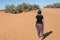 Woman walking in the dunes in the Moroccan Sahara desert