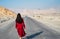 Woman walking on the empty dessert road