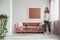 Woman walking in a feminine living room interior with a sofa, coffee table and painting