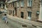 Woman walking in front of old houses in a cobblestone alley