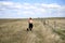 Woman walking her dog on the prairies of South Dakota.