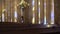 Woman walking between illuminated columns in cathedral