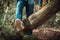 Woman walking on a log in the forest and balancing: physical exercise, healthy lifestyle and harmony concept