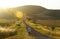 Woman walking long country road home sunset