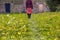 Woman walking in meadow towards rustic doors