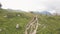 Woman walking on mountain trail while hiking tour drone view