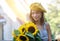 Woman is walking in the old town. He is holding a bouquet of autumn sunflowers in his hand