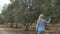 A woman is walking on an olive plantation