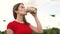 Woman walking in park drinking coffee, relaxing summer vacation, face smile. Sky on background