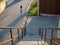 Woman walking past stairs and along path