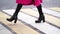 Woman is walking on pedestrian crossing at autumn day, closeup view on feet