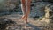 Woman is walking on rocks in summer, close up of legs