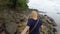 Woman walking on a rocky beach holding hands