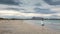 Woman walking San Teodoro sand beach with turquoise sea water and mountains of island Tavolara in Sardinia Italy