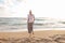 Woman walking on sand beach at golden hour