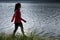 Woman walking on the shore of a lake against light