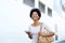 Woman walking on sidewalk with mp3 player and purse