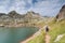 Woman walking in the spanish pyrenees by Estanes lake during sun