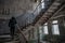 Woman walking by stair at the abandoned building at the ghost town Chernobyl