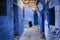 Woman walking in a street of the town of Chefchaouen in Morocco.