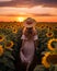 A woman walking through sunflowers in the sunshine. Nature countryside design