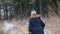 Woman walking through tall grass on forest trail in winter