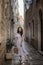 Woman walking in tiny street with stone buildings in old town Budva, Montenegro