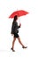 Woman walking under red umbrella