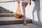 Woman walking up stairs and carrying reusable mesh bag after shopping food